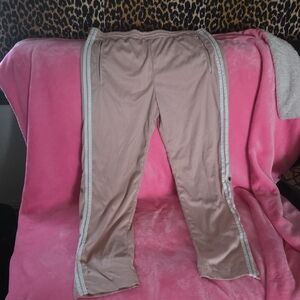 Women's track pants that has buttons on the legs and zippers for pockets.